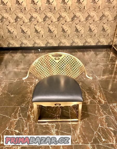 Elegantní židle ze zlatého kovu s černou kůži